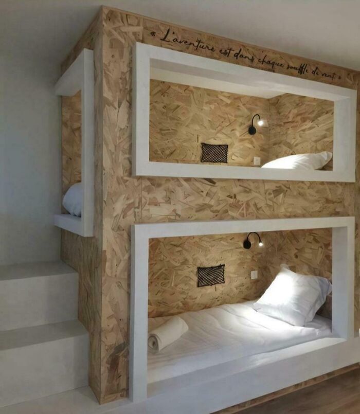 Bunk beds with awkward rectangular frames and plywood walls showing a DIY disaster in home design.