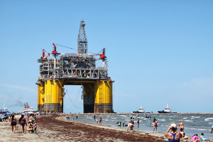 Beachgoers explore an unusual offshore oil platform near the shore, one of the bizarre things people found at the beach.