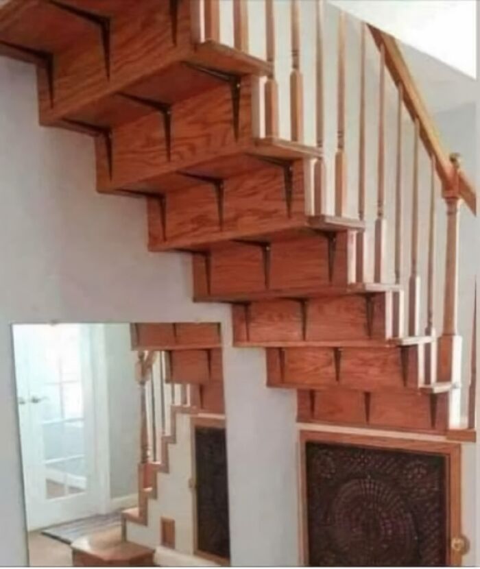 Wooden staircase DIY disaster with mirror reflecting a mismatched and confusing stair design mistake.