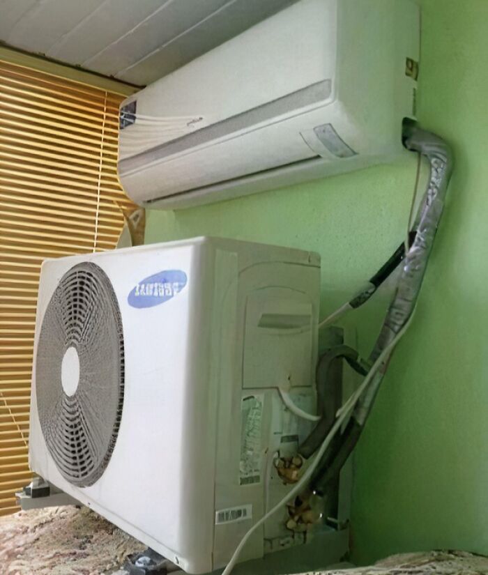 Indoor air conditioner unit with outdoor compressor improperly installed inside a room showing a DIY disaster.