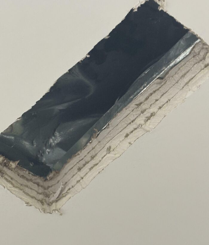 Patch job on ceiling with exposed layers and poorly applied duct tape showing a classic DIY disaster mistake.