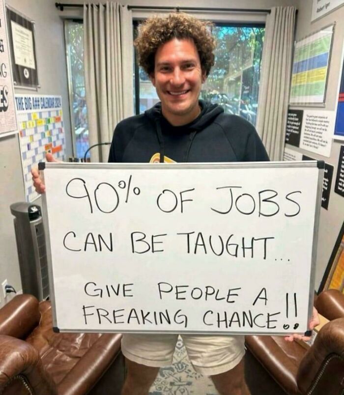 Man holding whiteboard with message about job training, highlighting outrageous job requirements that made people nope out quick.