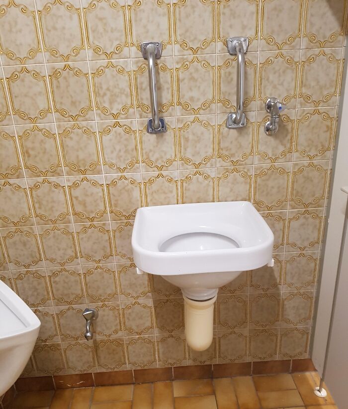 Retro styled bar bathroom sink with vintage tiles and metal handles, showcasing creative design elements in bars and restaurants.