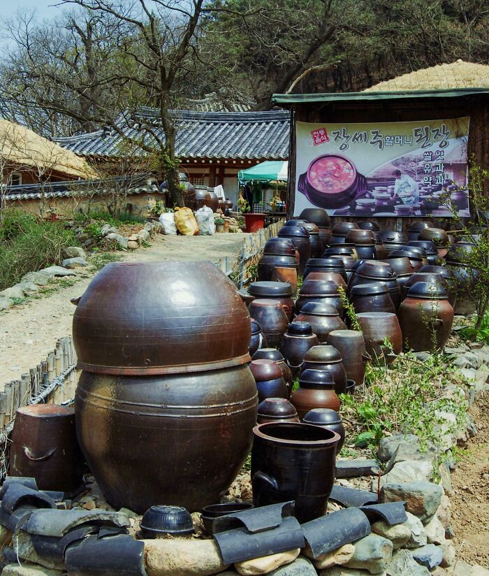 Traditional Korean pottery jars displayed outdoors at a creative bar and restaurant featured worldwide.