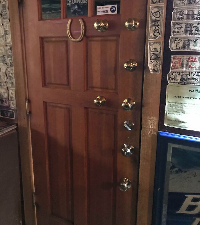 Wooden door with multiple locks and a horseshoe, part of creative bars and restaurants with unique decor.