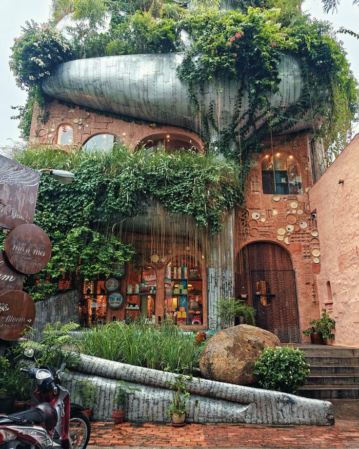 Creative bar and restaurant exterior with lush greenery and unique architectural design showcasing global creativity.