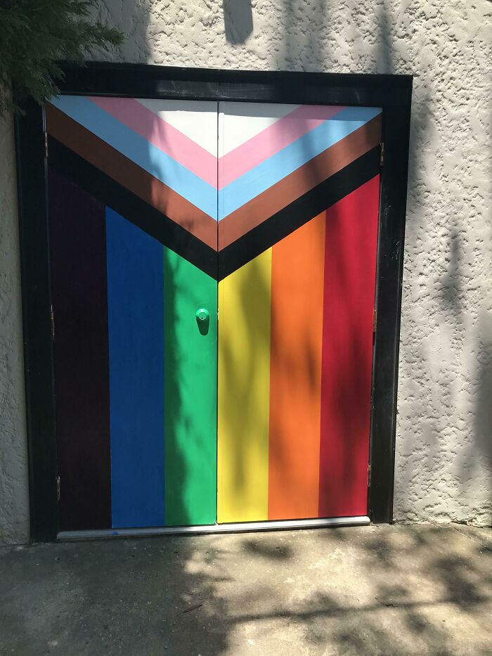 Colorful door painted with the rainbow and pride colors, representing wholesome kind neighbors in a vibrant neighborhood.
