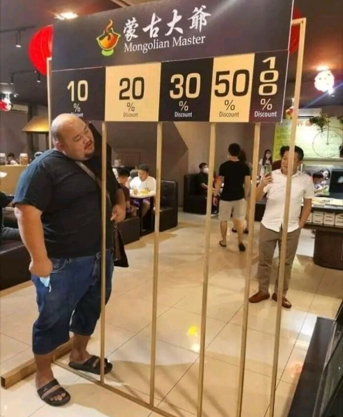 Man interacting with a creative discount display inside a Mongolian restaurant, showing various percentage offers.