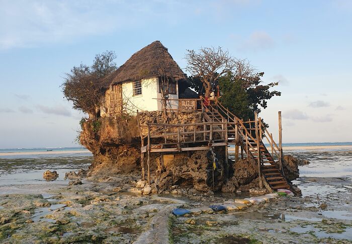 Unique creative bar perched on a rock formation by the sea, showcasing innovative design among bars and restaurants worldwide.
