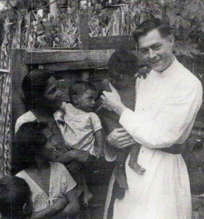 Black and white photo showing a man holding a child surrounded by several children, evoking 90s chilling disappearances mystery.