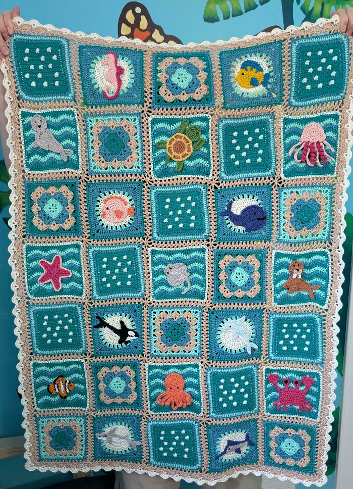 Crocheted blanket with sea animal motifs and decorative patterns showcasing skilled crocheting projects.