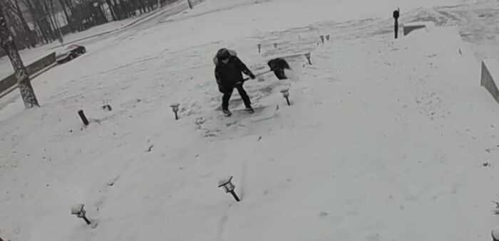 Person shoveling snow on a porch on a snowy day showing wholesome kind neighbors helping each other.