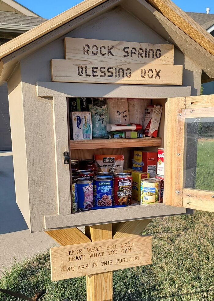 Wooden community blessing box filled with canned food and supplies, symbolizing wholesome kind neighbors sharing resources.