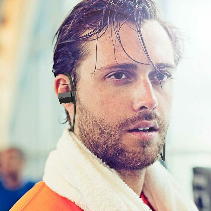 Close-up of a man with a blurred background wearing wireless earphones in a clear example of Photoshop fails.