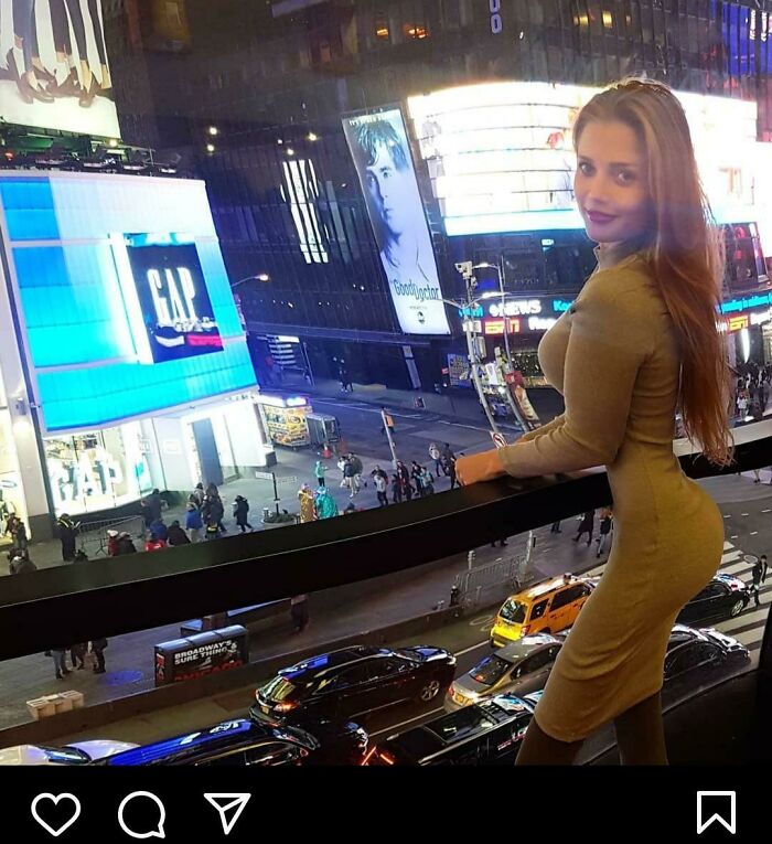 Woman in a tight dress overlooking a busy city street at night, showcasing a clear example of Photoshop fails.