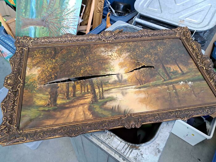 Damaged antique landscape painting with a large tear, illustrating selfish people losing all common decency.