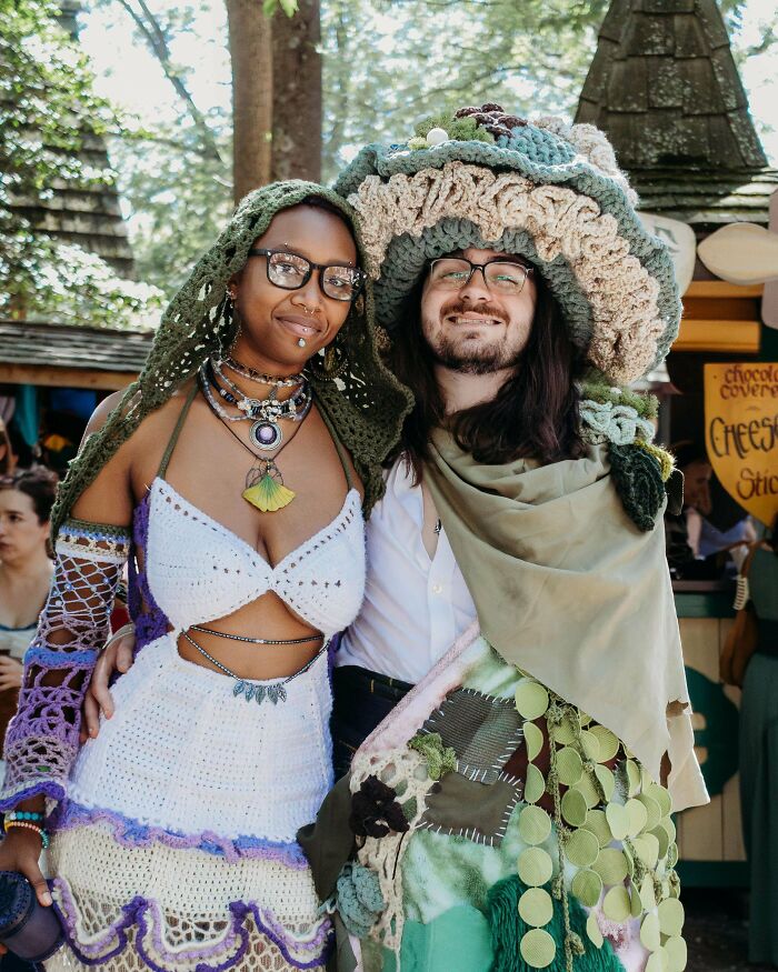 Two people wearing intricate crocheted outfits and accessories, showcasing handmade crochet art and designs.