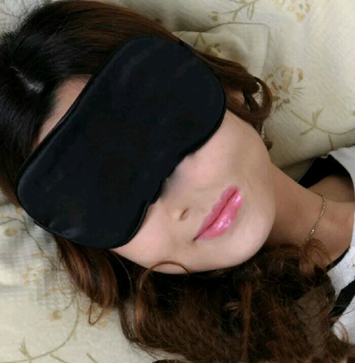 Woman lying down wearing a black eye mask with a Photoshop fail showing an extra nose on her face.