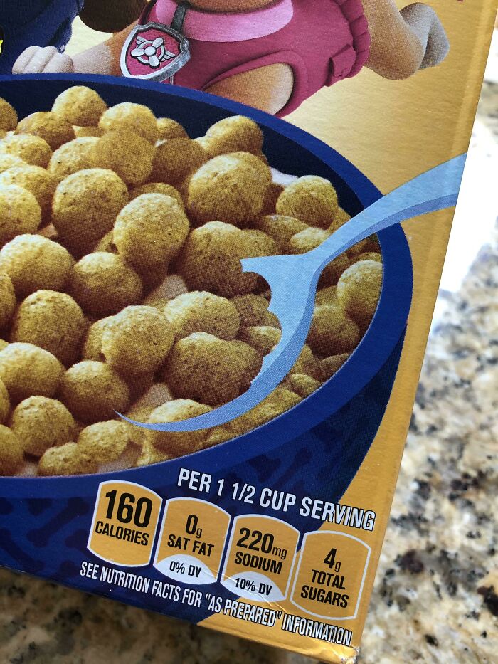 Close-up of cereal box nutrition label showing a Photoshop fail with the spoon partially cut off in the image design.