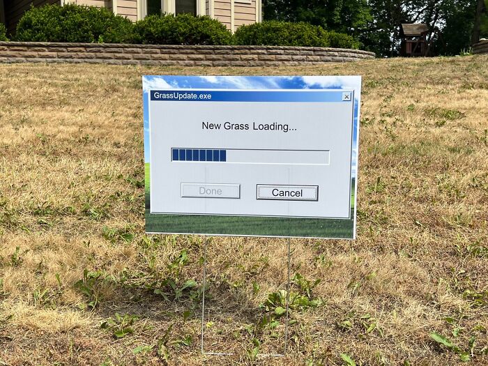 Funny sign in dry grass designed like a computer update window showing new grass loading progress bar.