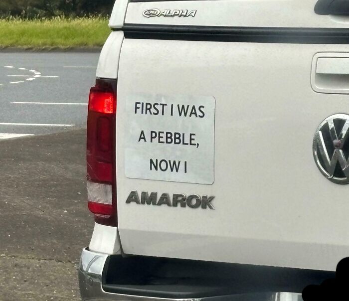 Sticker with a random humorous note on a white Volkswagen Amarok truck reminding not to take life too seriously.