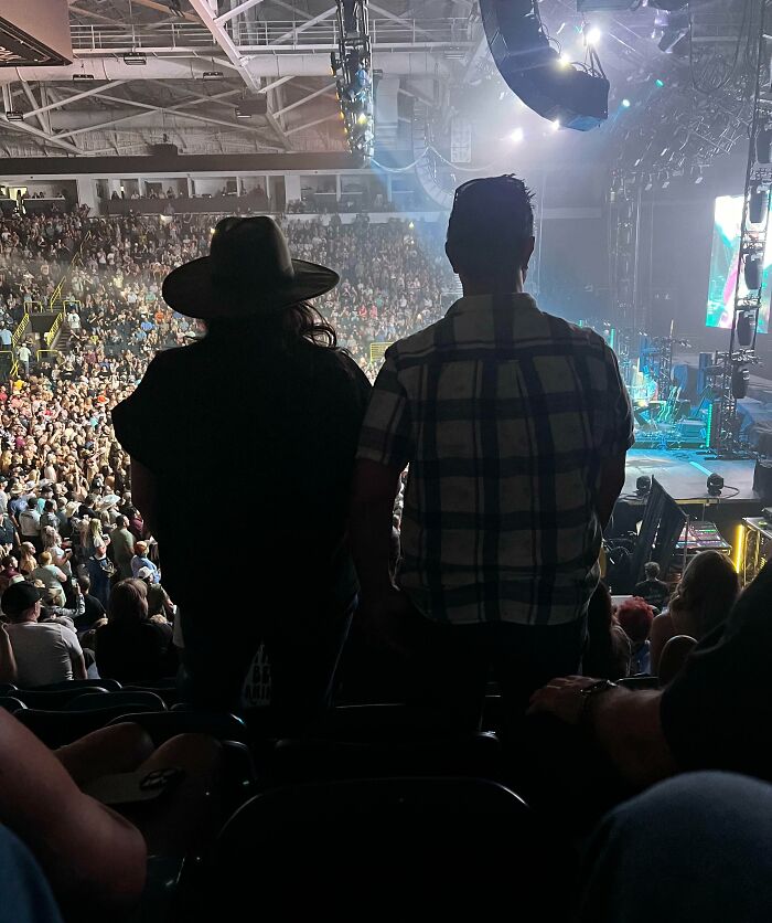 Crowded concert scene with two people standing in front, illustrating selfish people losing common decency in public spaces.
