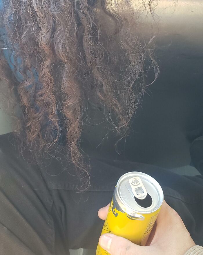 Person with curly hair holding an open can, illustrating selfish people making life harder for everyone else.