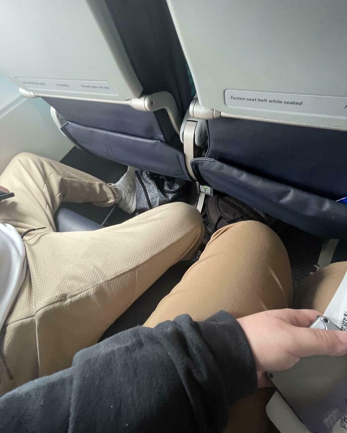 Legroom conflict between selfish people on a plane, showing how lost common decency makes travel harder for others.