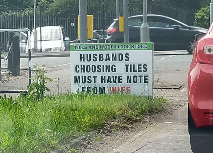 Funny roadside sign with random notes reminding husbands choosing tiles must have a note from wife for humor and fun.