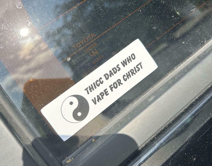 Sticker on car window with a yin-yang symbol and a humorous, random note reminding not to take life too seriously.