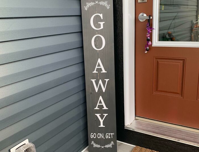 Wooden outdoor sign with funny random message saying Go Away, Go On, Get, reminding us not to take life too seriously.