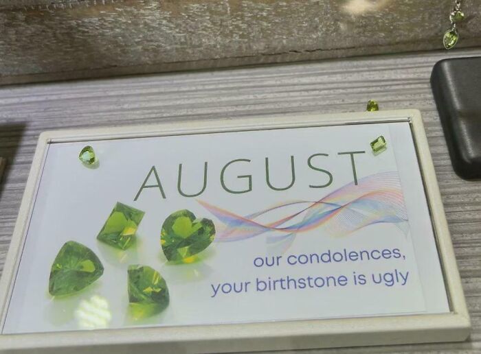 Sign with green gemstones labeled August and a humorous note reminding not to take life too seriously in random messages.