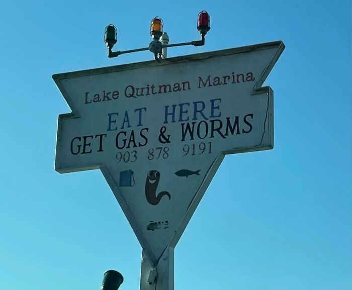 Funny roadside sign at Lake Quitman Marina offering food, gas, and worms, showcasing hilariously random notes and messages.
