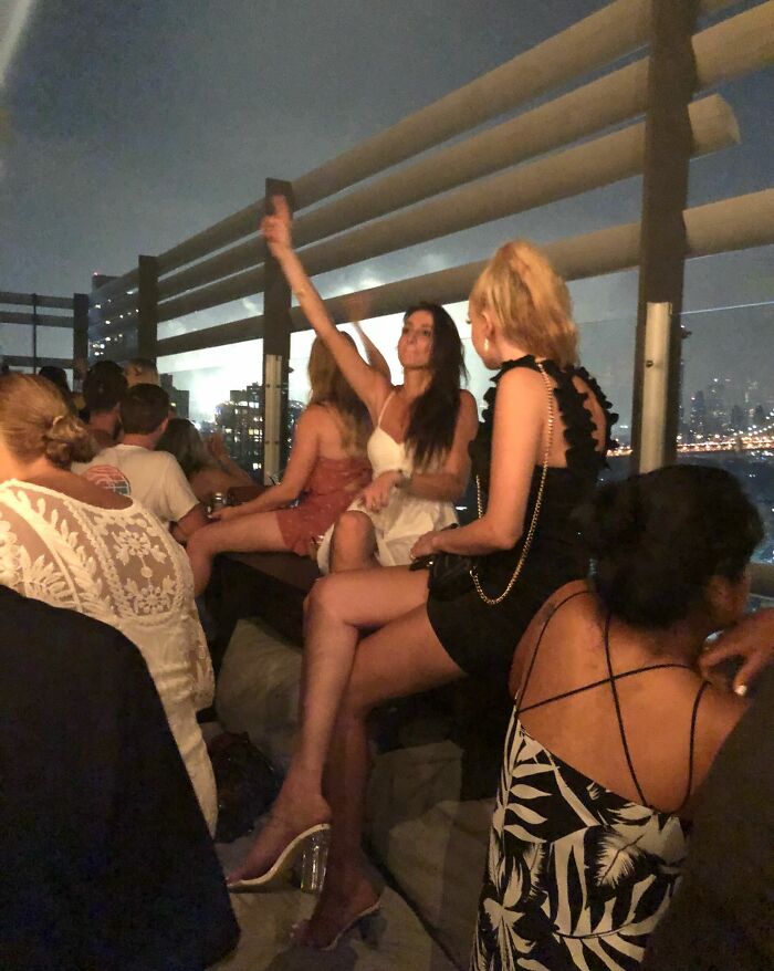 Group of people at a rooftop party at night showing moments where selfish people lost common decency around others.