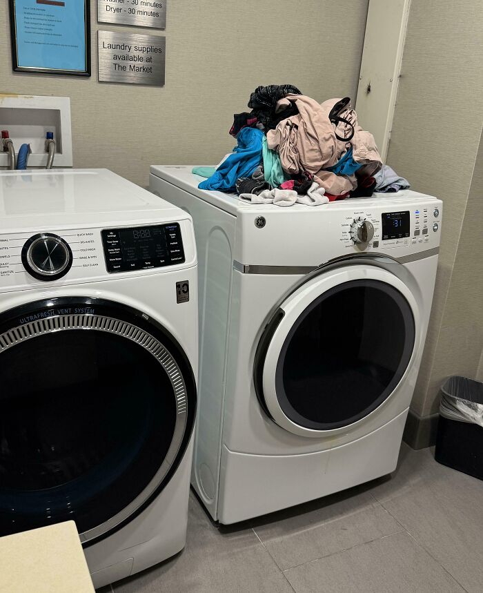 Laundry room with washer and dryer, selfish people leaving clothes piled up, causing inconvenience for everyone else.