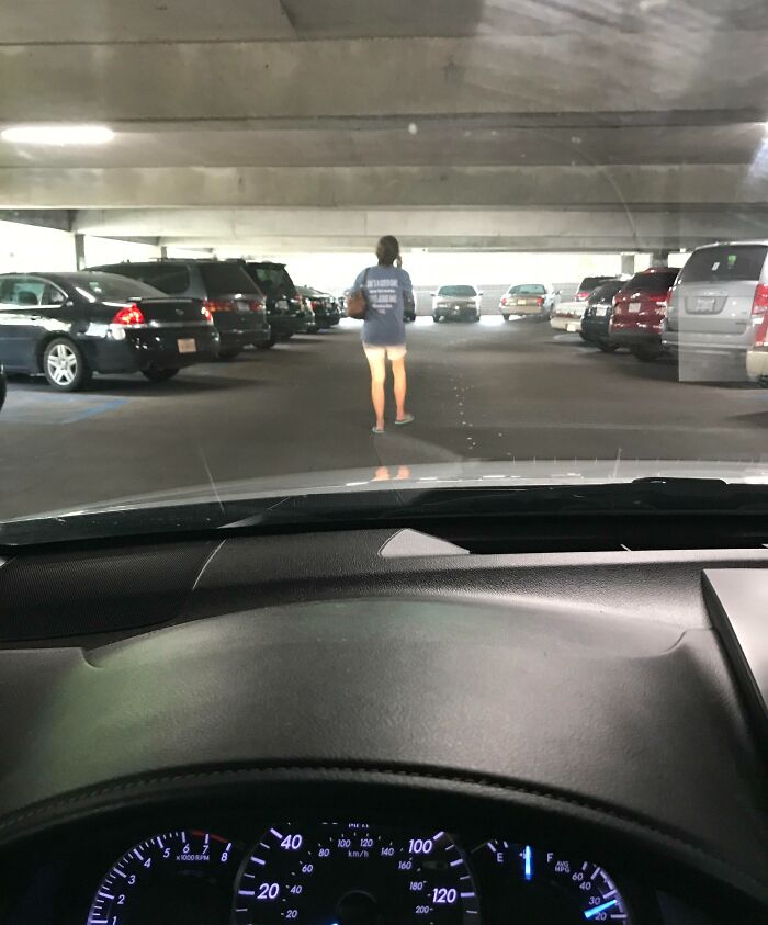 View from inside a car showing selfish people blocking a parking garage lane, causing inconvenience to others.