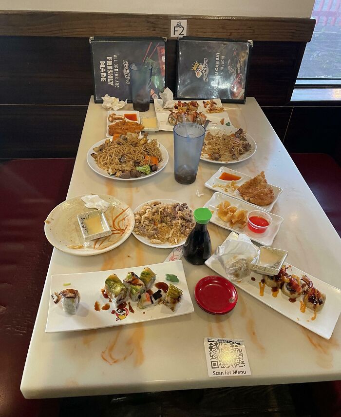 Partially eaten Asian food and sushi on a table showing selfish people lost common decency and made life harder for others.