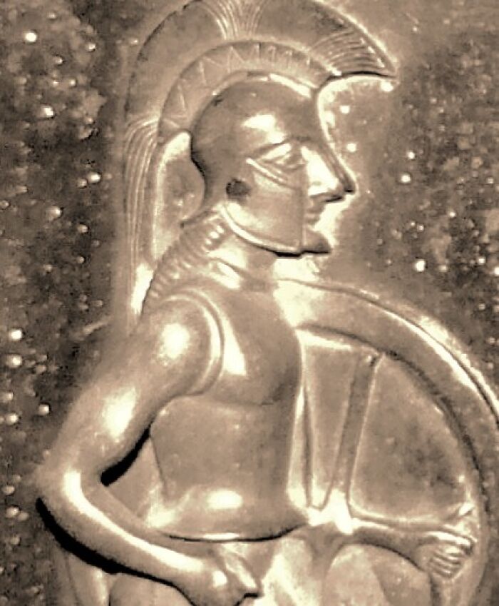 Ancient warrior sculpture in armor holding a shield, representing strength and savage roasts in historic form.