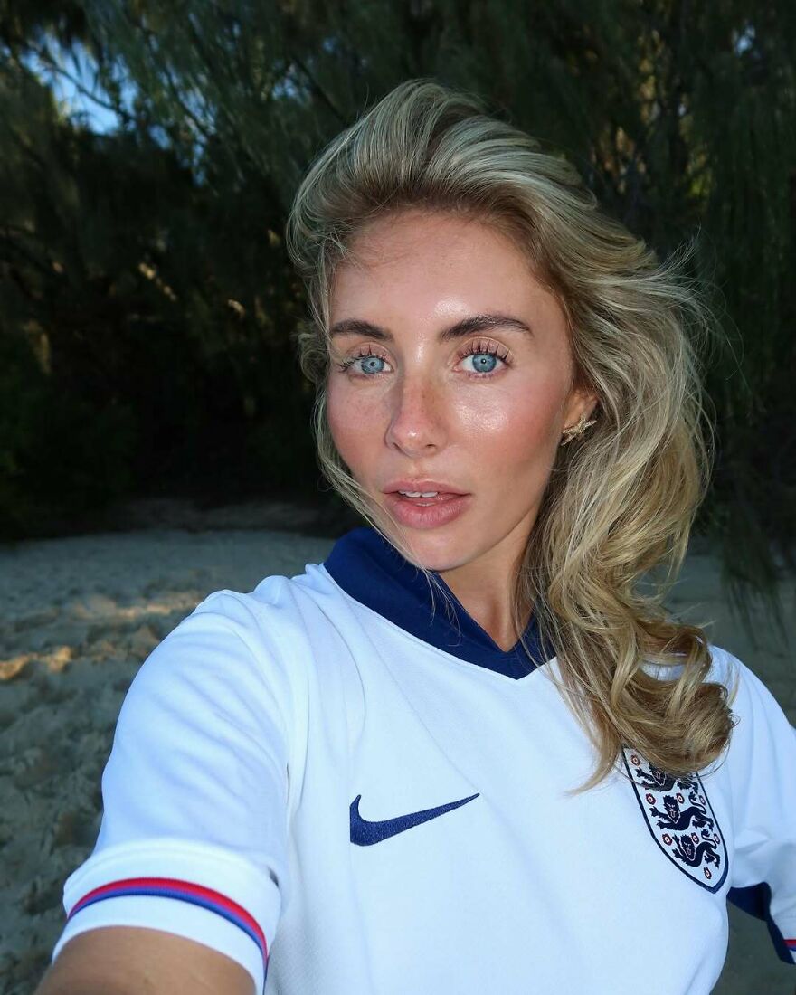 Bonnie Blue outdoors wearing a white sports jersey with blue accents, showcasing her natural look and blonde hair. Bonnie Blue outdoors wearing a white sports jersey with blue accents, showcasing her natural look and blonde hair.