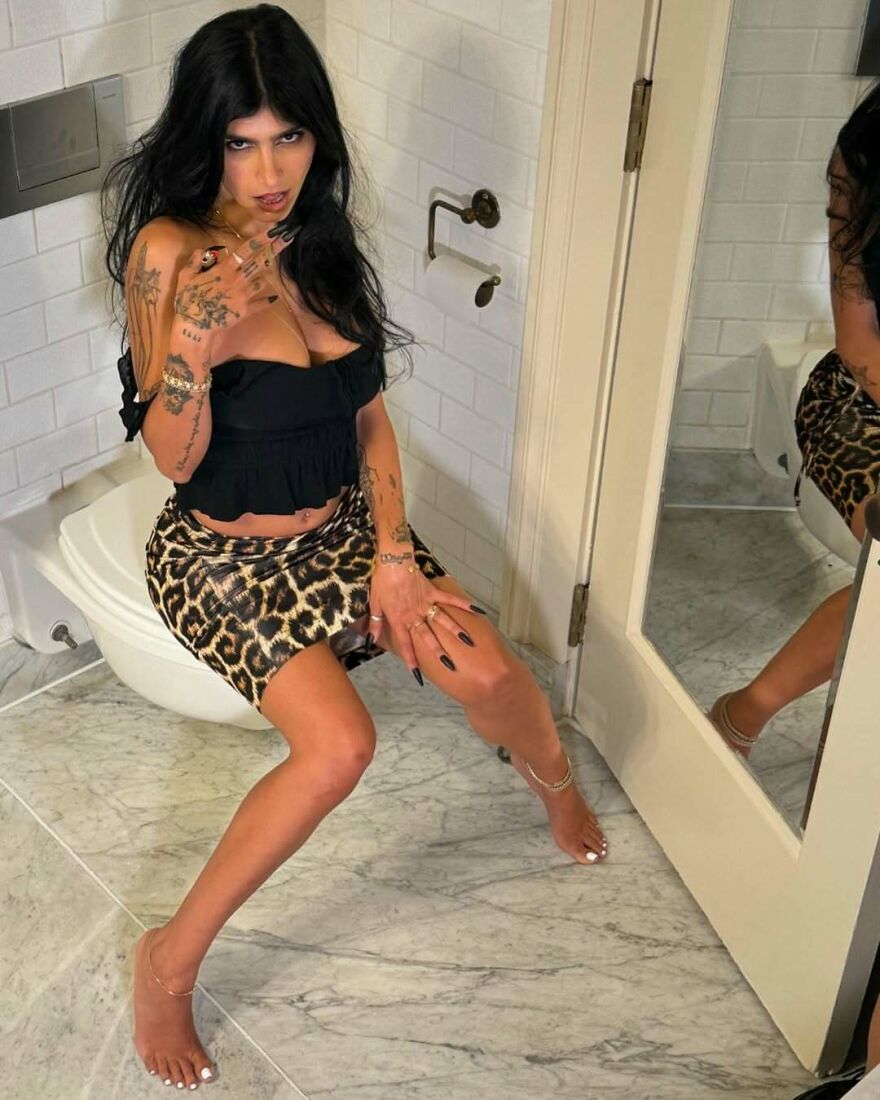 Woman with tattoos wearing a black top and leopard skirt posing in a bathroom, related to Bonnie Blue’s net worth topic. Woman with tattoos wearing a black top and leopard skirt posing in a bathroom, related to Bonnie Blue’s net worth topic.