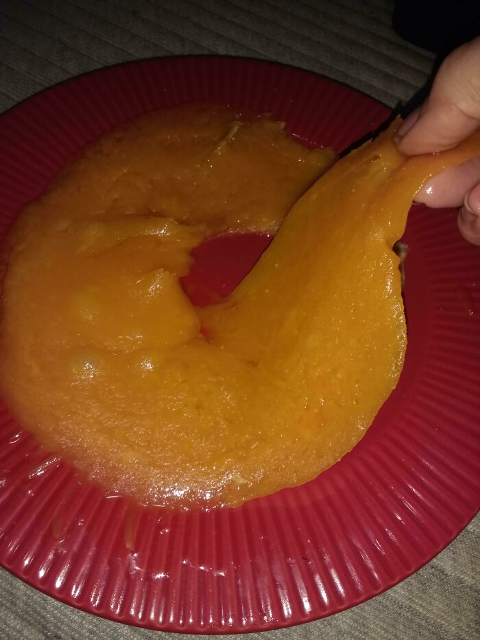 Unusual food order on red plate showing a hand peeling an odd, stretchy orange substance, restaurant workers dealing with strange requests.