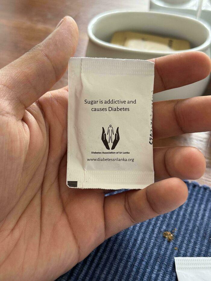Hand holding a sugar packet with diabetes warning, highlighting restaurant workers handling surprising orders.