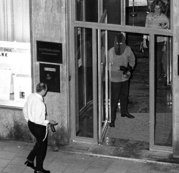 Masked man holding a b**b inside a bank during a tense moment captured in weird history pics highlighting unusual past events.
