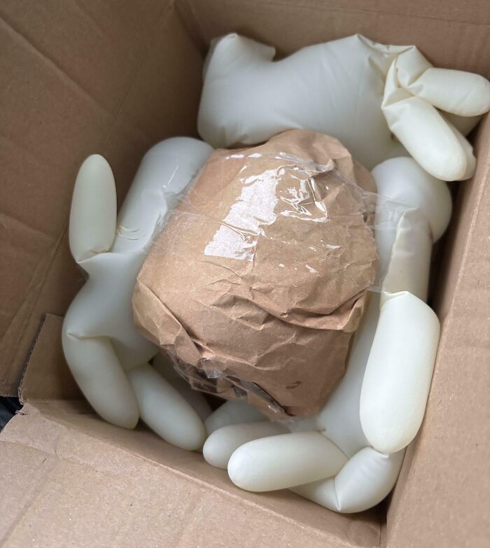 Packing a fragile item using inflated medical gloves for protection, demonstrating genius life hacks people actually use.