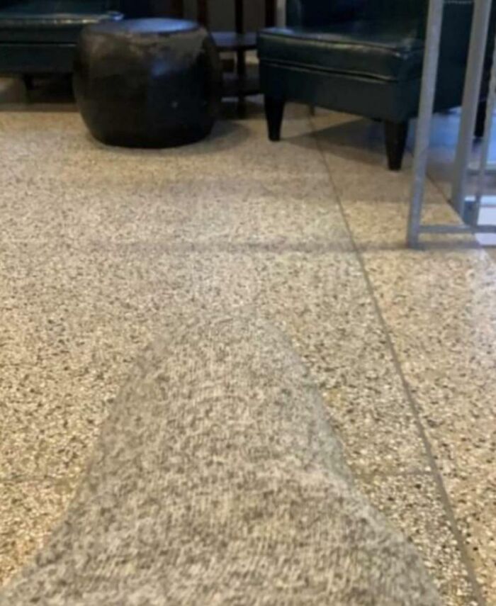 Leg blending into a speckled floor perfectly, showcasing things that matched their surroundings so well in a living room.
