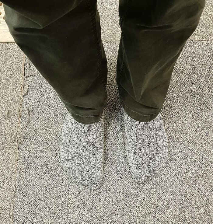Socks perfectly matched the textured carpet, blending seamlessly with the surrounding floor pattern.