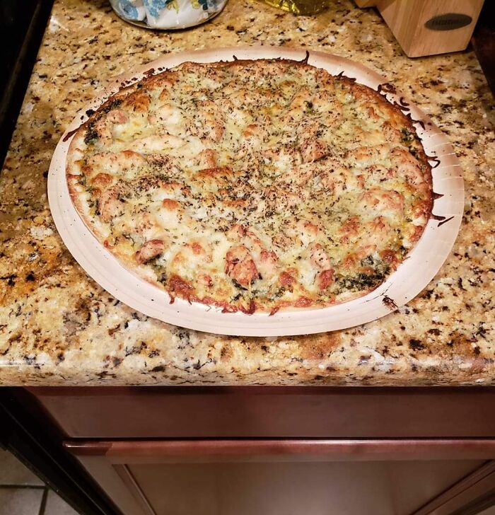 Pizza placed on a granite countertop with a similar color and pattern, blending perfectly with its surroundings.