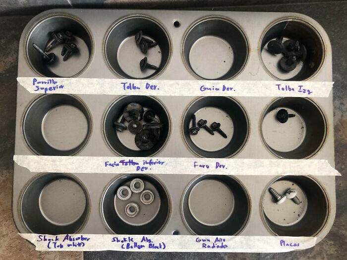 Muffin tin organizer with labeled compartments holding screws and washers, demonstrating genius life hacks for tool storage.