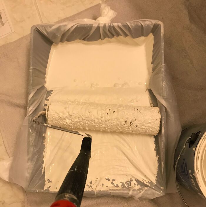 Paint roller cleaning hack with plastic liner in tray, showing a genius life hack for easy paint cleanup.