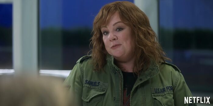 Woman in a green military jacket talking in a dimly lit room, scene from Netflix movies that turned out to be letdowns